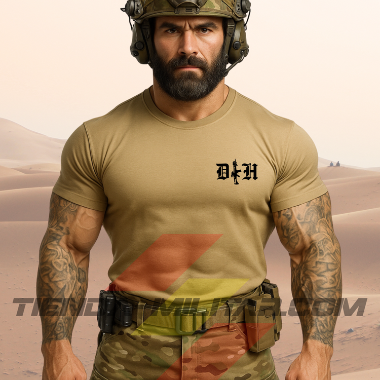 Hombre de frente con camiseta táctica fabricada en algodón, en color arena de la marca Depredador Hispano en un entorno desértico. En el pecho lleva un logotipo con con las iniciales de la marca (DH) y un fusil de asalto G36 en vertical. Ropa militar de alto rendimiento con diseño reivindicativo de poder hispano.