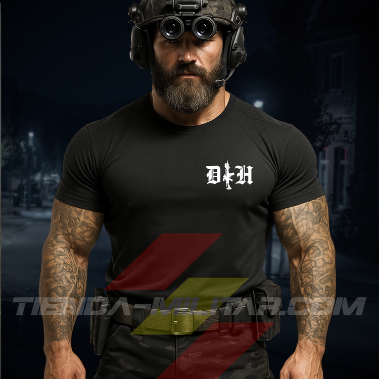 Hombre de frente con camiseta táctica fabricada en algodón, en color negro de la marca Depredador Hispano en un entorno nocturno y urbano. En el pecho lleva un logotipo con con las iniciales de la marca (DH) y un fusil de asalto G36 en vertical. Ropa militar de alto rendimiento con diseño reivindicativo de poder hispano.