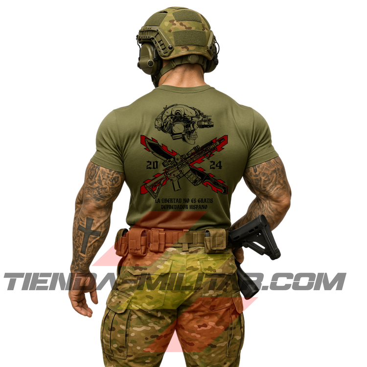 Soldado de espaldas con una camiseta táctica de ALGODÓN  premium, de color VERDE MILITAR y un logo grande con una cruz de Borgoña en color ROJO, casco táctico moderno con una calavera, fusil de asalto tipo AR15, machete cruzado y la frase “LA LIBERTAD NO ES GRATIS”. Todo de la marca táctica Depredador Hispano. Ropa militar de alto rendimiento con diseño reivindicativo de poder hispano.