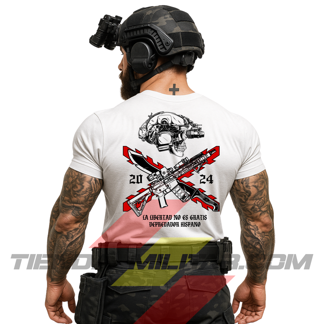 Soldado de espaldas con una camiseta táctica de ALGODÓN  premium, de color BLANCO y un logo grande con una cruz de Borgoña en color ROJO, casco táctico moderno con una calavera, fusil de asalto tipo AR15, machete cruzado y la frase “LA LIBERTAD NO ES GRATIS”. Todo de la marca táctica Depredador Hispano. Ropa militar de alto rendimiento con diseño reivindicativo de poder hispano.