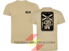 Cargar imagen en el visor de la galería, Camiseta táctica de algodón premium, color arena de la marca Depredador Hispano. En el pecho lleva un logotipo con con las iniciales (DH) y un fusil de asalto G36 en vertical. En la espalda la frase “TIEMPOS DUROS, HOMBRES FUERTES”. Ropa militar de alto rendimiento con diseño reivindicativo de poder hispano.
