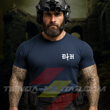 Cargar imagen en el visor de la galería, Hombre de frente con camiseta táctica fabricada en algodón, en color AZUL MARINO de la marca Depredador Hispano en un entorno nocturno,  urbano Y RUINOSO. En el pecho lleva un logotipo con con las iniciales de la marca (DH) y un fusil de asalto G36 en vertical. Ropa militar de alto rendimiento con diseño reivindicativo de poder hispano.
