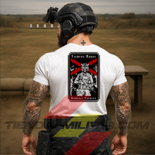 Cargar imagen en el visor de la galería, Hombre de espaldas con camiseta táctica de algodón, en color blanco militar de la marca Depredador Hispano en un campo de tiro. En la espalda lleva la frase “TIEMPOS DUROS, HOMBRES FUERTES”. Ropa militar de alto rendimiento con diseño reivindicativo de poder hispano.
