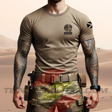 Cargar imagen en el visor de la galería, Hombre de frente con camiseta táctica color arena de Depredador Hispano en un entorno desértico. En el pecho lleva un logotipo con calavera táctica y casco, y en la espalda la frase “AQUÍ SE HABLA ESPAÑOL” junto a un fusil sobre fondo de Cruz de Borgoña. Ropa militar de alto rendimiento con diseño hispano.
